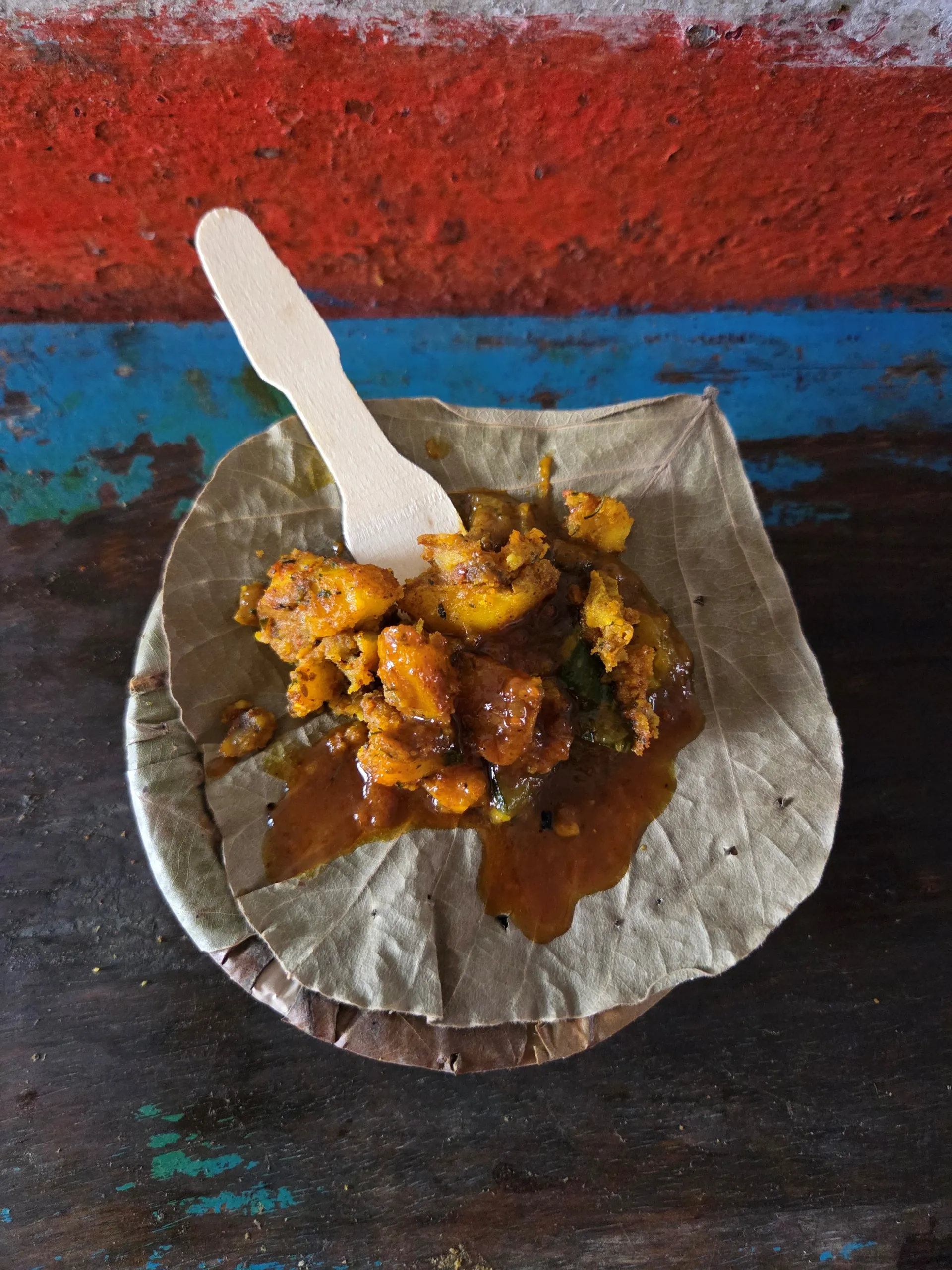 Street food and a wooden spoon in a leaf bowl in Lucknow