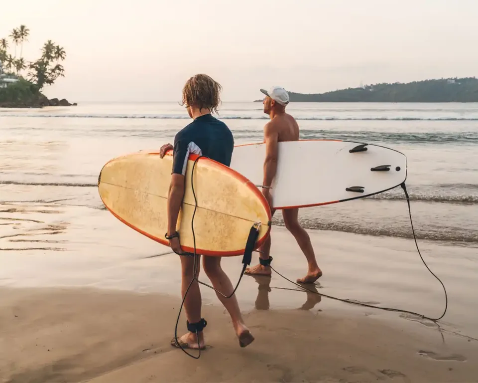 Two surfers walking into the sea on Sri Lanka south coast